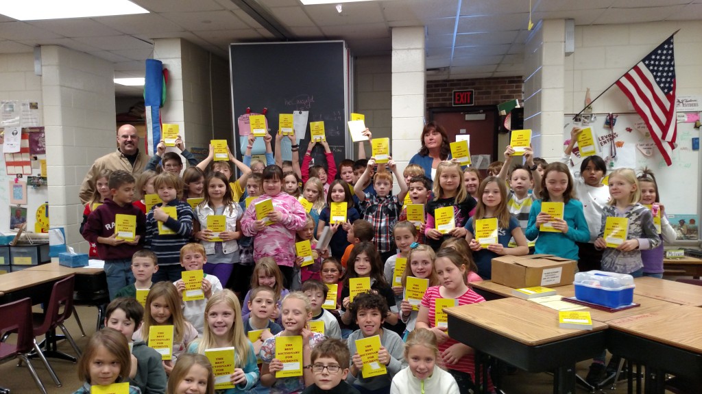 Students proudly holding their new dictionaries
