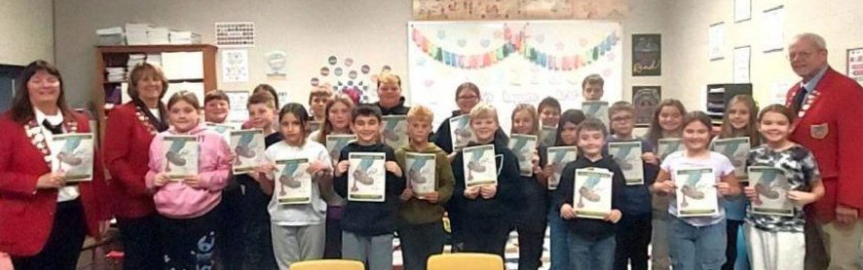 Students and sponsors holding dictionaries